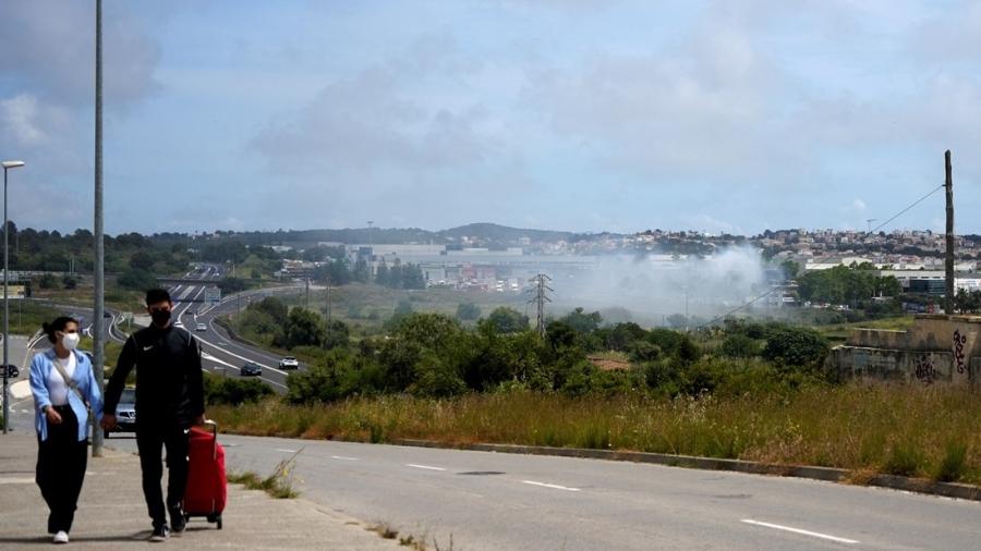 De máscara, casal caminha ao lado de foco de incêndio que causou nuvem tóxica na Espanha - REUTERS/Eric Renom