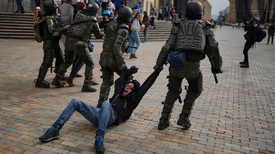 Manifestante é arrastado por policiais durante protesto em Bogotá, na Colômbia - Xinhua/Jhon Paz