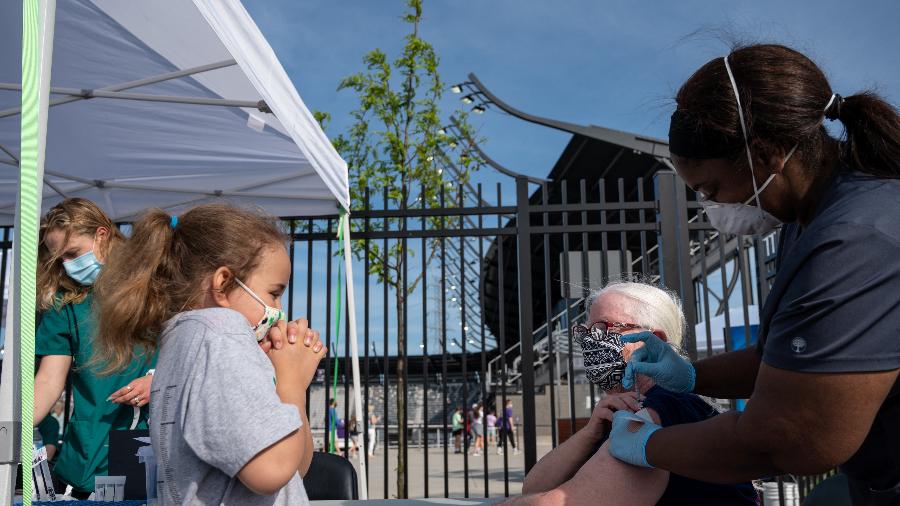 26.abr.2021 - Criança reage ao ver a avó receber dose de vacina contra a covid-19 em Louisville, Kentucky, nos EUA - Jon Cherry/Getty Images via AFP