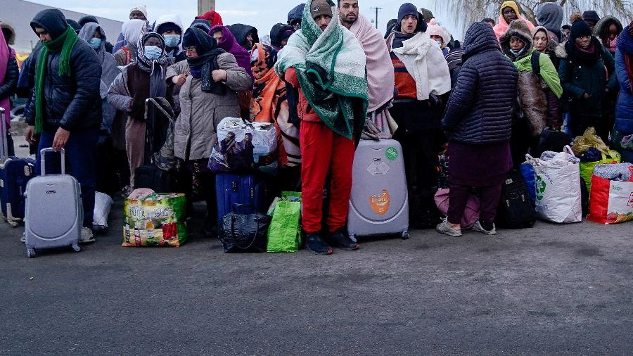 28.fev.22 - Pessoas que fugiram da invasão russa na Ucrânia esperam para embarcar em um ônibus com destino a um centro de refugiados estabelecido em Przemysl, em Medyka, na Polônia