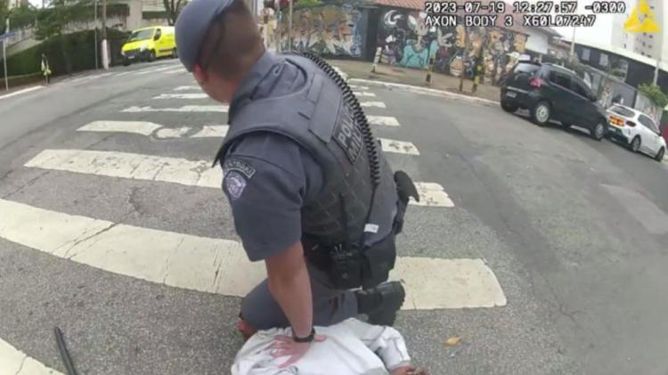 Policial apoia o joelho sobre o pescoço do homem já rendido