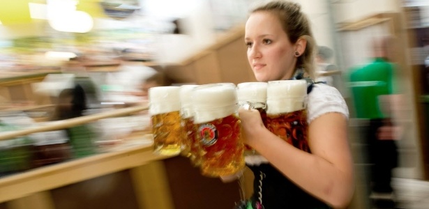 Garçonete corre com canecas de cerveja para servir os visitantes da 182ª Oktoberfest - Sven Hoppe/EFE