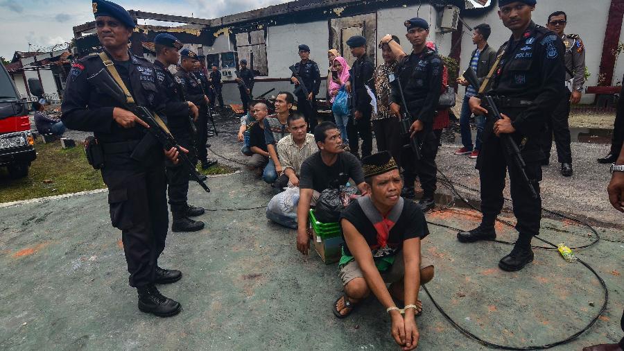 Polícia armada se prepara para transferir presos após tumultos e um incêndio em um centro de detenção  -  Wahyudi/AFP