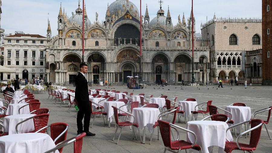 Garçom contempla falta de movimento em restaurante na Praça de São Marcos, em Veneza, frente ao número de contágios de covid-19, doença causada pelo novo coronavírus, na Itália - Manuel Silvestri/Reuters