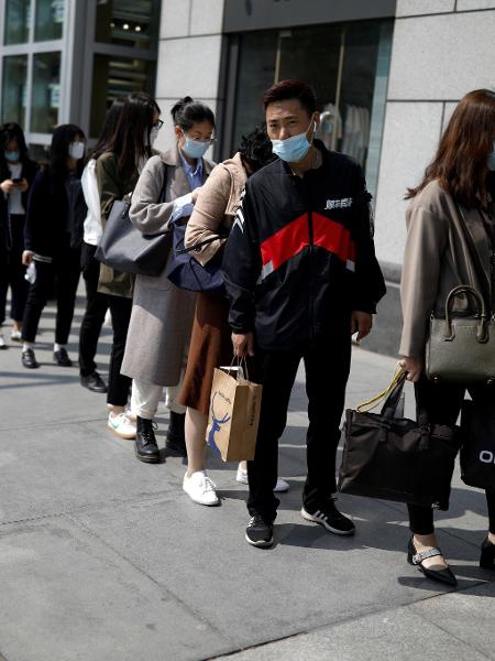 Arquivo -Pessoas usam máscara por causa do coronavírus para entrar em edifício empresarial em Pequim, na China - Carlos Garcia Rawlins/Reuters
