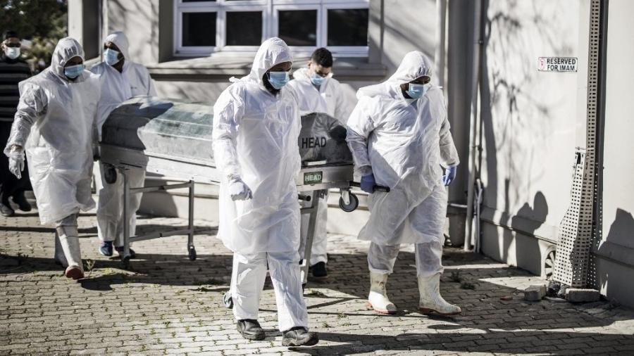 16.jun.2020 - Agentes funerários carregam caixão com corpo de vítima do novo coronavírus, na Cidade do Cabo, na África do Sul - Marco Longari/AFP