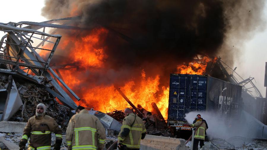 Os bombeiros libaneses apagam incêndio no local de uma explosão no porto da capital Beirute - 4 de agosto de 2020 - STR / AFP