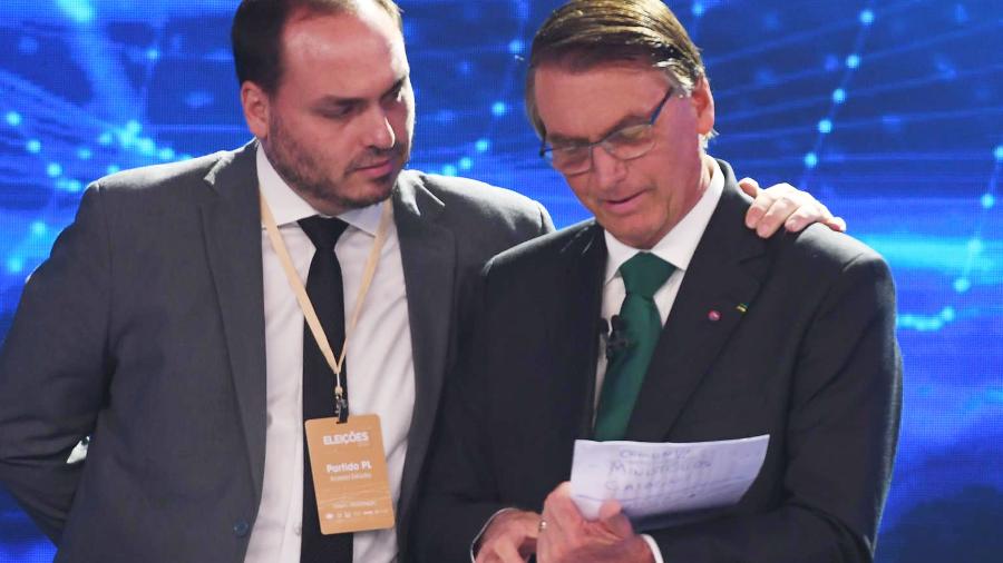Carlos Bolsonaro e o presidente Jair Bolsonaro durante o debate da Band, em SP