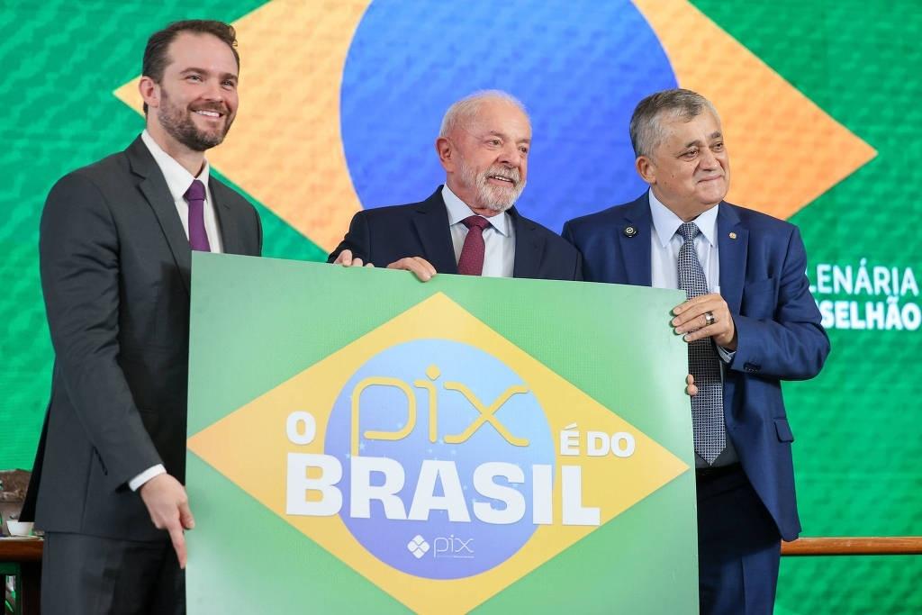 Da esq. para dir, Dario Durigan (Fazenda), Lula e José Guimarães (Relações Institucionais) mostram cartaz em defesa do Pix durante reunião do Conselhão  - undefined