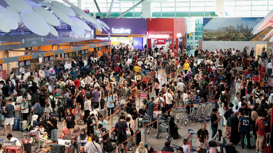 Passageiros da AirAsia esperam para fazer o check-in manualmente no Terminal 2 do Aeroporto Internacional de Kuala Lumpur, após uma interrupção global do sistema de TI, em Sepang, Malásia, 19 de julho de 2024