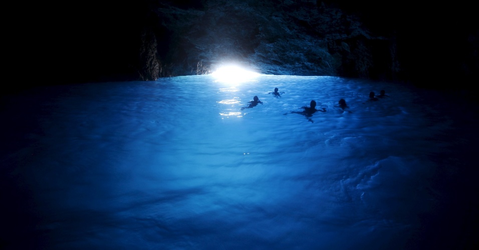 30.jul.2015 - Turistas nadam na caverna da lagoa azul, na ilha Kastellorizo, na Grécia