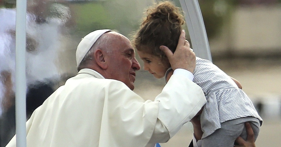 20.set.2015 - O papa Francisco beija uma criança na chegada à Praça da Revolução, em Havana, onde ele celebra missa