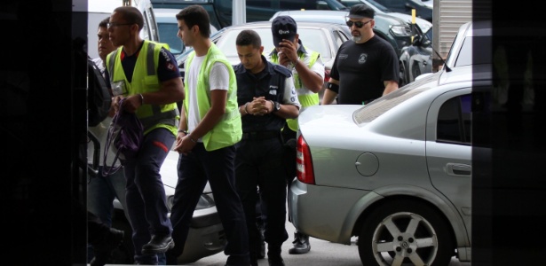 Com uniformes do aeroporto, funcionários detidos durante a operação são levados à sede da PF, no Rio - José Lucena/Futura Press/Estadão Conteúdo