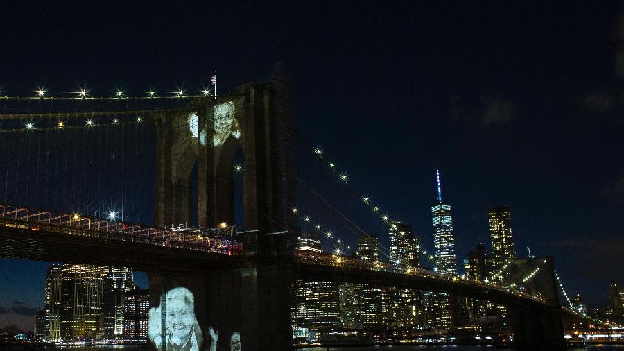 14.mar.2021 - Imagens de vítimas da covid-19 são projetadas na ponte do Brooklyn, em Nova York - Kena Betancur/AFP