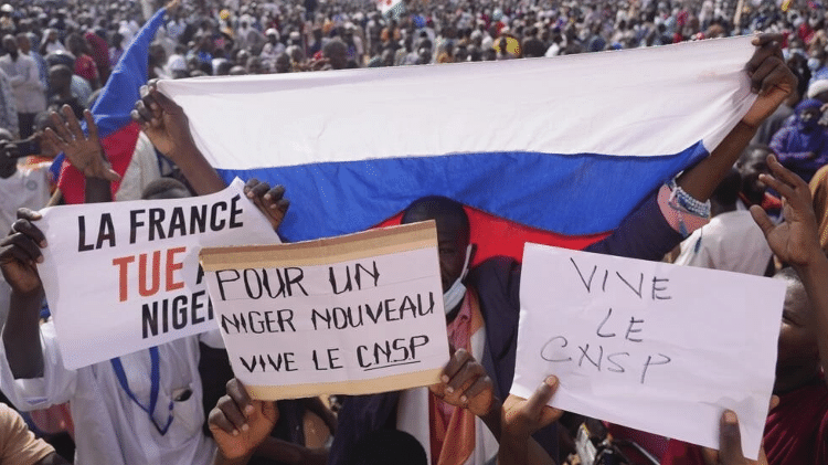 Manifestantes favoráveis ao golpe militar exibem cartazes com as frases 'França assassina' 
