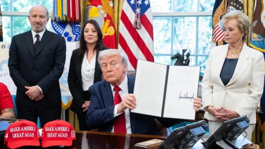 23.abr.2025 - O presidente Donald Trump assina ordens executivas relacionadas à educação superior nos EUA - SAUL LOEB / AFP