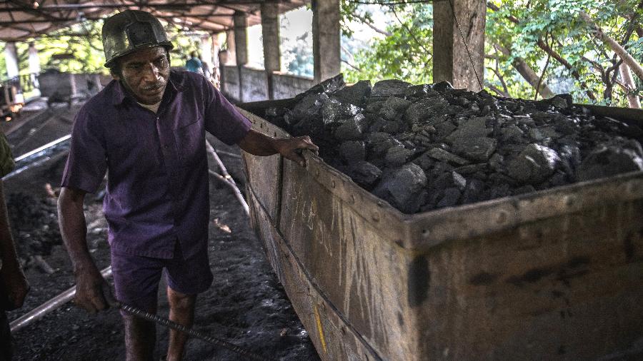 Mineiro descarrega carvão extraído de uma mina no estado de Telangana, na Índia - Rebecca Conway/The New York Times