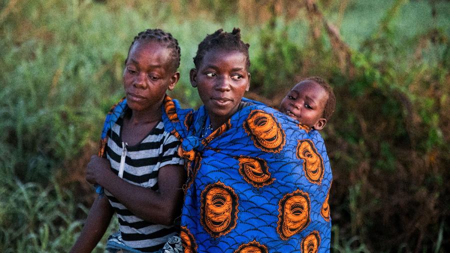 Amélia Augusto (e), que perdeu o filho na enchente, com sua vizinha Ester Carama e Laucina, de 2 anos, em Búzi, Moçambique - Neil Collier/The New York Times
