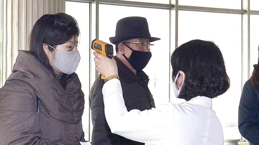 Voluntários realizando triagem de temperatura em campanha antivírus em Pyongyang, na Coreia do Norte - KCNA via REUTERS/File Photo