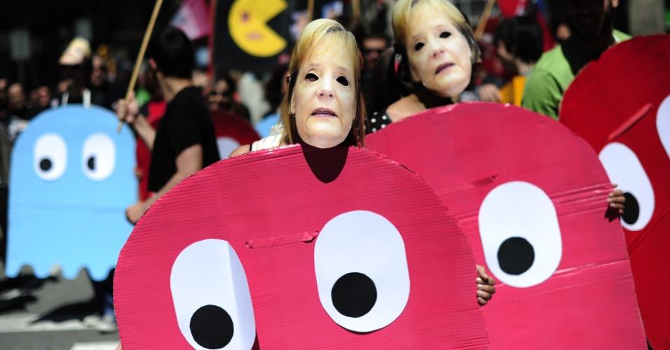 1.mai.13 - Manifestantes vestidos como personagens do jogo de vídeo-game Pac-Man e com máscaras da chanceler alemã, Angela Merkel, participam de protesto no Dia do Trabalho em Barcelona, na Espanha. Os espanhóis foram às ruas pelos direitos dos trabalhadores e contra as políticas anticrise adotadas pelo governo