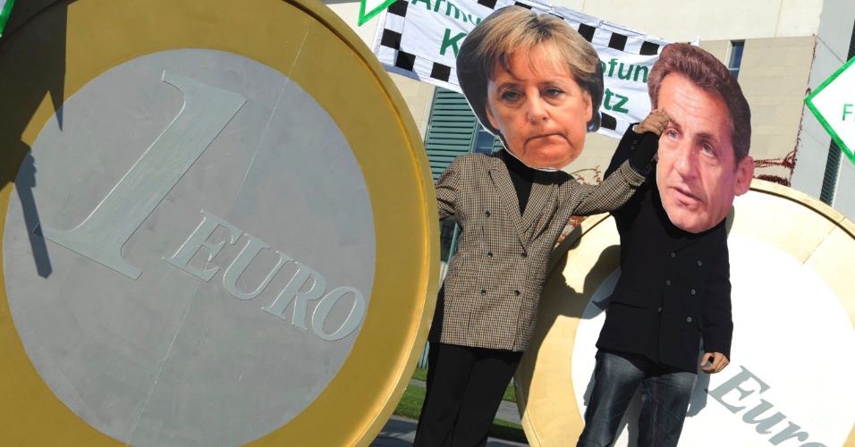 21.out.11 - Ativistas com máscaras da chanceler alemã, Angela Merkel, e do então presidente francês, Nicolas Sarkozy, fazem protesto em Berlim exigindo impostos na transação financeira de ajuda à Grécia. A dupla de políticos defensores de cortes nos orçamentos públicos foi apelidada de "Merkozy"