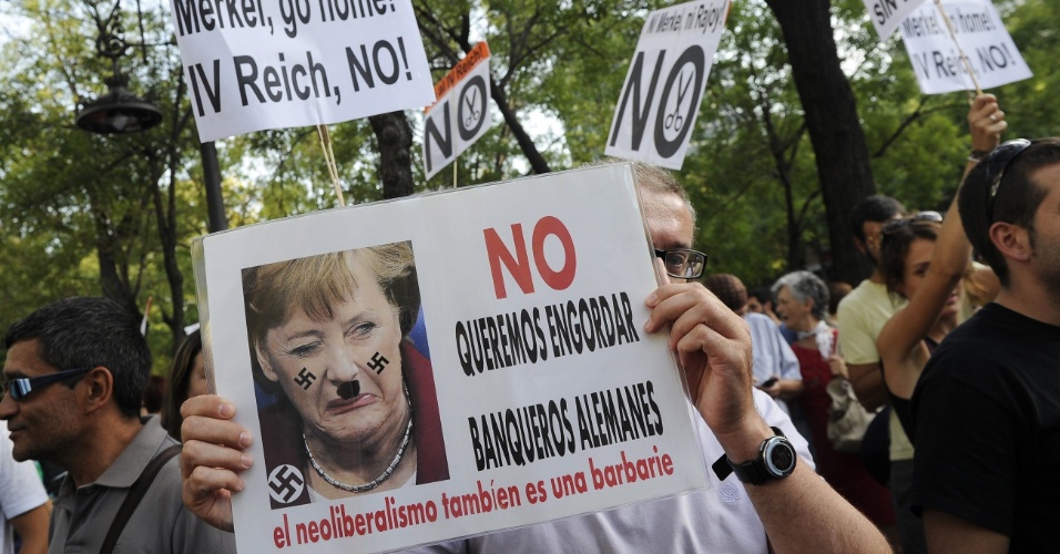 6.set.12 - Manifestante segura cartaz onde está escrito ?Não queremos engordar os banqueiros alemães? em protesto durante a visita da chanceler alemã, Angela Merkel, em Madri, na Espanha