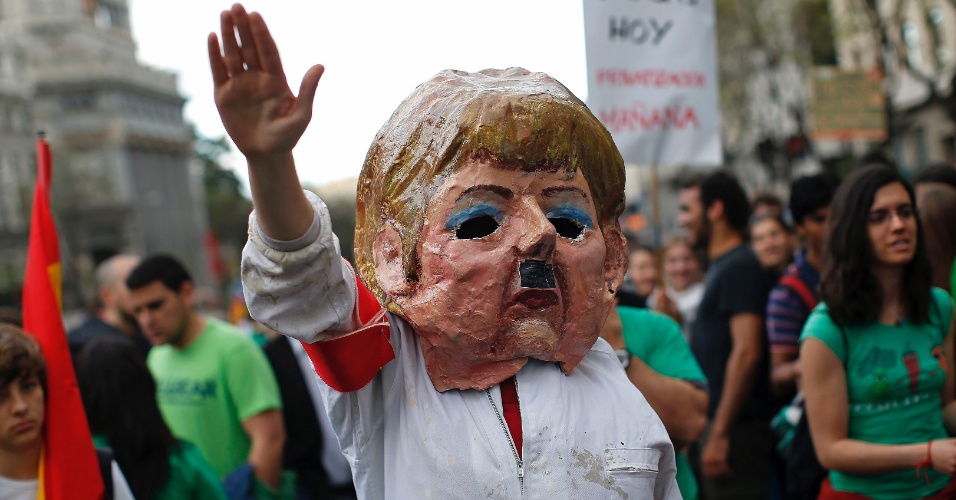 9.mai.2013 - Manifestante veste máscara de Angela Merkel e ergue o braço direito, imitando a saudação nazista, em protesto contra os cortes do governo espanhol na área de educação, durante greve nacional do setor, em Madri