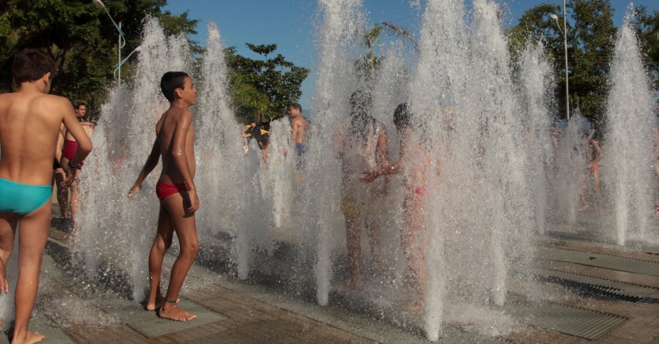 1.jun.2013 - Banhistas da praia de Caraguatatuba, no litoral norte de São Paulo, aproveitam altas temperaturas para se refrescarem em uma espécie de chafariz