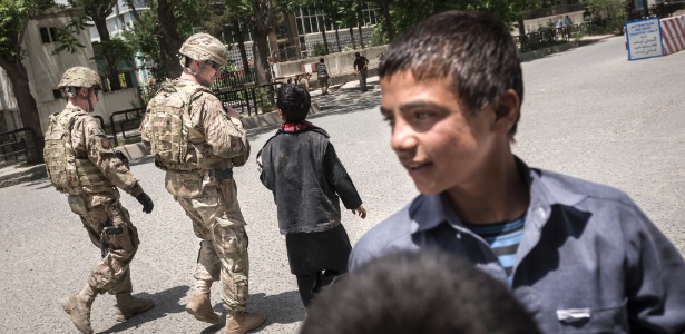 Crianças trabalham como vendedores ambulantes em frente a complexo militar da International Security Assistance Force (ISAF) em Cabul, no Afeganistão - Sergey Ponomarev/The New York Times