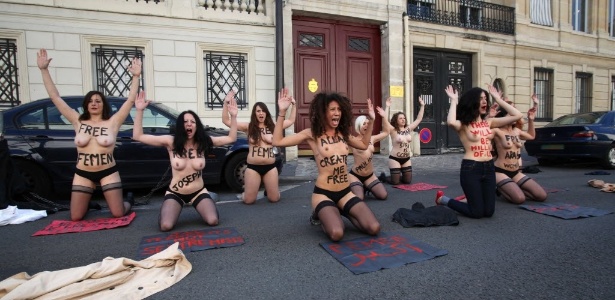 Ativistas do grupo feminista simulam oração em frente à embaixada da Tunísia em Paris nesta quarta-feira - Claire Lebertre/AFP
