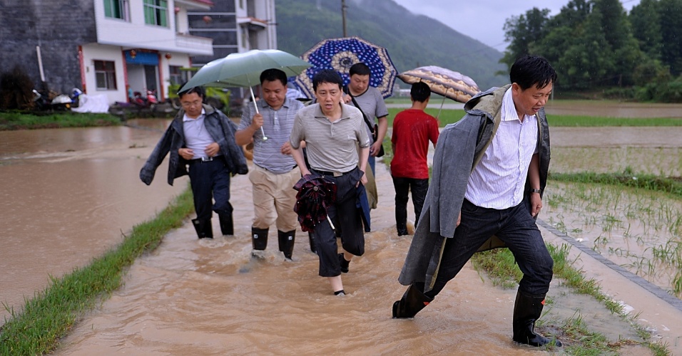 7.jun.2013 - Em foto de quinta-feira (6) divulgada hoje, pessoas andam uma rua inundada em Xuanen, na província chinesa de Hubei. As tempestades que atingem a região desde quarta-feira (5) afetaram cerca de 400 mil pessoas e já causaram prejuízos de cerca de 150 milhões de yuans (aproximadamente R$ 50 milhões), segundo a mídia local