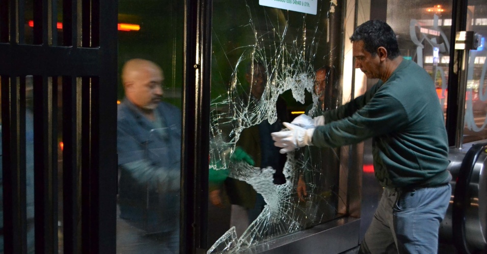 7.jun.2013 - Funcionários manuseiam vidro quebrado na entrada do metrô Trianon Masp após protesto na avenida Paulista, em São Paulo, contra o aumento da passagem de ônibus, na noite desta quinta-feira (6). Segundo a Polícia Militar, mil pessoas se reuniram e 15 foram detidas