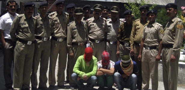 Policiais posam para foto com três homens suspeitos de estuprar uma turista americana de 30 anos na cidade de Manali, no norte da Índia - 7.jun.2013 - Sanjay Baid/EFE
