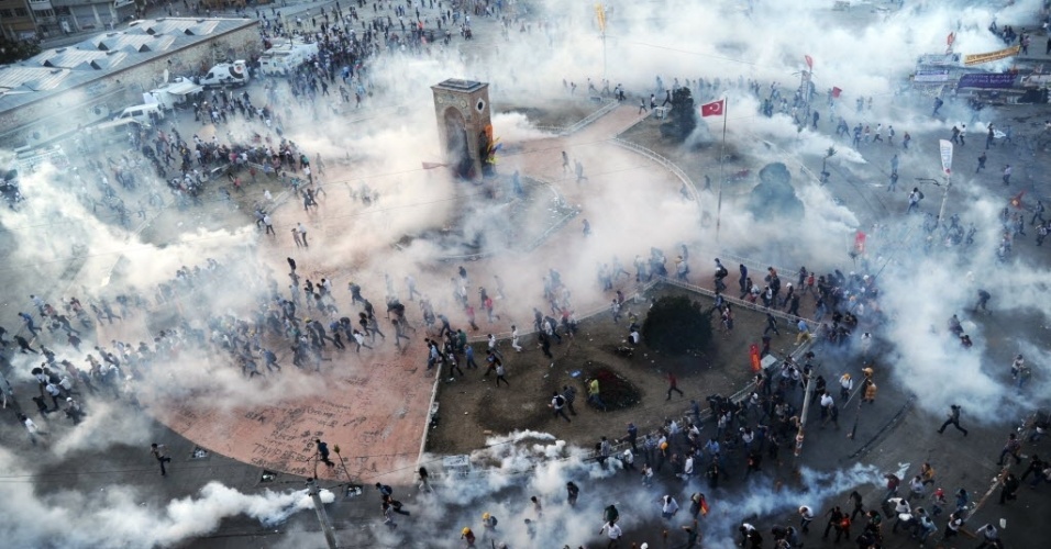 11.jun.2013 - Manifestantes correm em meio à fumaça produzida por diversas bombas de gás lacrimogênio lançadas pela polícia em confronto na praça Taksim, em Istambul, na tarde desta terça-feira (11). Os manifestantes conseguiram voltar ao local após terem sido retirados pela polícia durante a manhã, dando continuidade aos conflitos