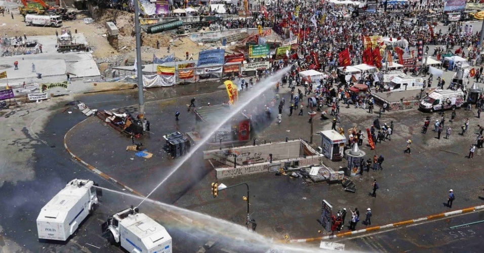 11.jun.2013 - Manifestantes correm enquanto policiais atiram com canhão de água durante confrontos em Istambul, na Turquia, nesta terça-feira (11). Dezenas de policiais anti-protestos tomaram a praça Taksim, em Istambul, nesta manhã. O local é o epicentro das manifestações que agitam o país a mais de duas semanas e de onde a policia não se aproximava há doze dias. Foram utilizadas bombas de gás lacrimogênio e blindados com canhões de água na operação