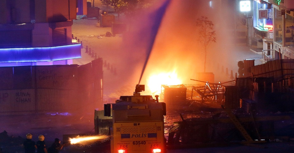 11.jun.2013 - Policiais disparam gás lacrimogêneo e usam caminhões de água contra manifestantes na praça Taksim, em Istanbul, na Turquia. A policia turca passou a noite combatendo grupos de manifestantes após ações, durante o dia, de retomada a força da praça Taksim, vizinha ao parque