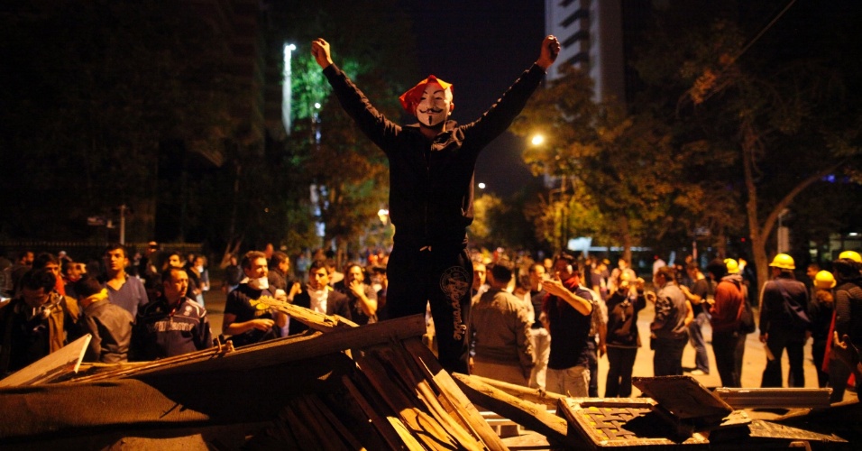 12.jun.2013 - Manifestantes usa máscara durante mais uma noite de protestos anti-governo em Ancara, na Turquia. Os protestos na Turquia, iniciados em 31 de maio por causa de um projeto de remodelação do parque Gezi, em Istambul, se tornaram uma revolta contra o governo do primeiro-ministro Recep Tayyip Erdogan