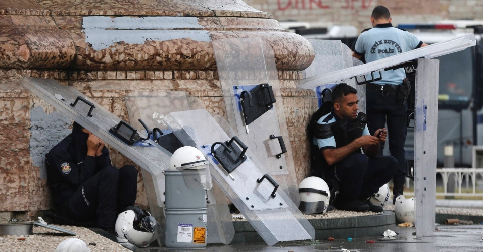 12.jun.2013 - Policiais descansam na praça Taksim, no centro de Istambul, na Turquia, na manhã desta quarta-feira (12). A policia turca passou a noite combatendo grupos de manifestantes após ações, durante o dia, de retomada a força da praça, vizinha ao parque