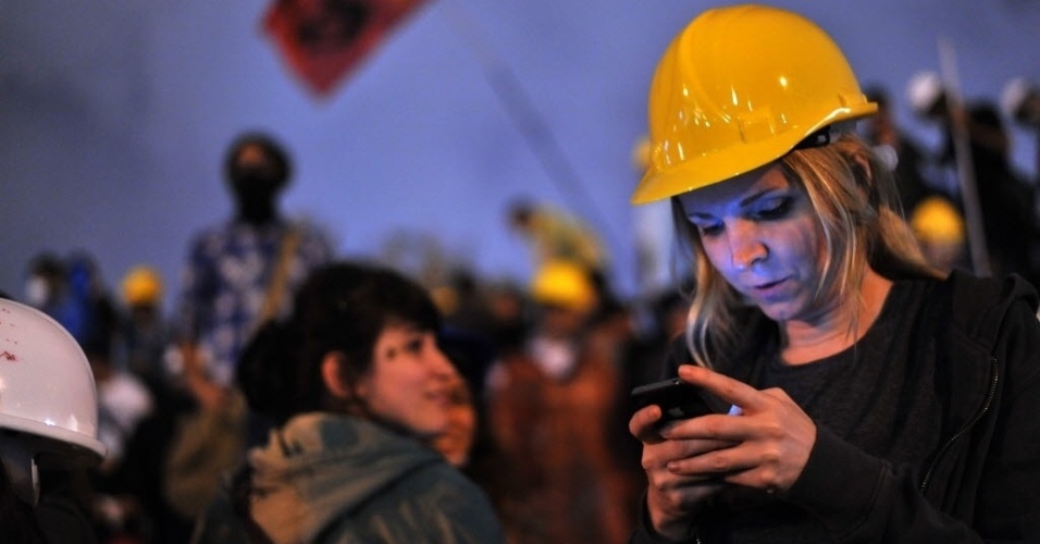 13.jun.2013 - Mulher usa seu smartphone para acompanhar noticiário sobre manifestações no parque Gezi, em Istambul