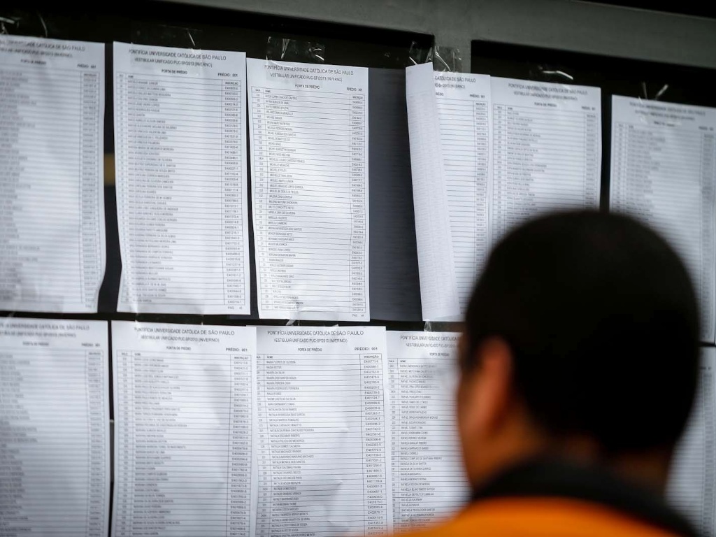 Candidatos aguardam o início das provas do vestibular 2013 de inverno da PUC-SP (Pontifícia Universidade Católica de São Paulo) na manhã deste domingo (16). A partir das 14h, o UOL terá a correção online feita pelos professores do Curso e Colégio Objetivo. No total, são oferecidas 2.028 vagas, sendo 940 para a PUC-SP, 30 para a FASM (Faculdade Santa Marcelina), 408 para a FRB (Faculdades Integradas Rio Branco) e 650 para a Unifai (Centro Universitário Assunção) - Leandro Moraes/UOL