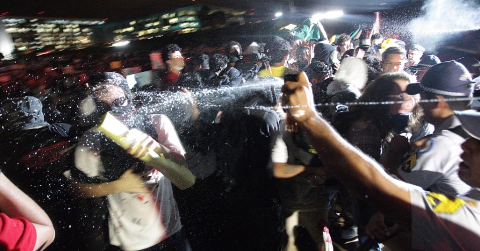 17.jun.2013 - Policial usa spray para conter manifestante durante protesto que segue pela Esplanada dos Ministérios até o Congresso Nacional em Brasília, na noite desta segunda-feira. Alguns manifestantes tentam invadir o Congresso Nacional subindo pelas rampas