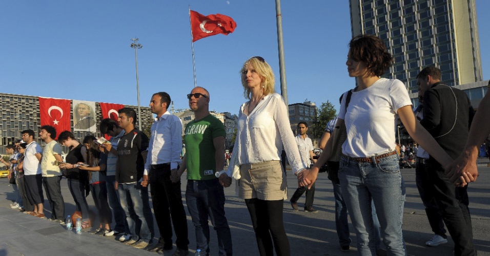 19.jun.2013 - Manifestantes decidem protestar em silêncio de mãos dadas, em Ancara, capital da Turquia