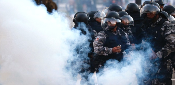 Policiais se protegem de bombas de gás lacrimogêneo durante protesto nas imediações da Arena Fonte Nova, em Salvador, antes de jogo da Copa das Confederações disputado no dia 20 de junho - Kai Pfaffenbach/Reuters