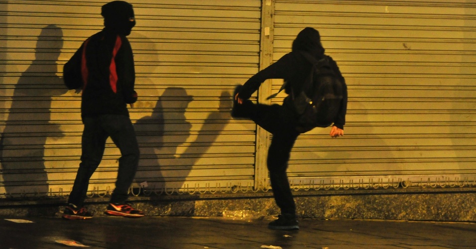 24.jun.2013 - Manifestante chuta porta de loja durante protesto em Porto Alegre, na noite desta segunda-feira (24). A cavalaria da Brigada Militar dispersou manifestantes e prendeu 15 vândalos