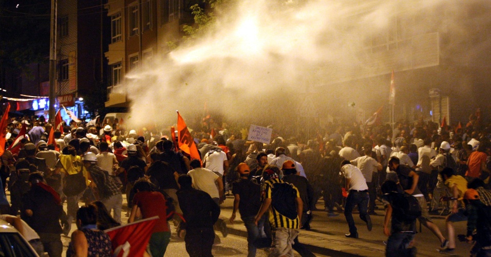 25.jun.2013 - Manifestantes correm de jatos de água disparados pela polícia durante confrontos em Ancara, na Turquia, durante protesto na noite desta terça-feira (25). Quatro pessoas morreram desde o início das manifestações, em 31 de maio, contra o governo islamo-conservador, no poder na Turquia desde 2002