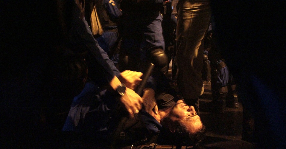 25.jun.2013 - Policial é ferido em confronto com manifestantes que atiravam pedras e rojões contra a polícia na avenida Borges de Medeiros, uma das principais do centro de Porto Alegre, na noite de segunda-feira (24)