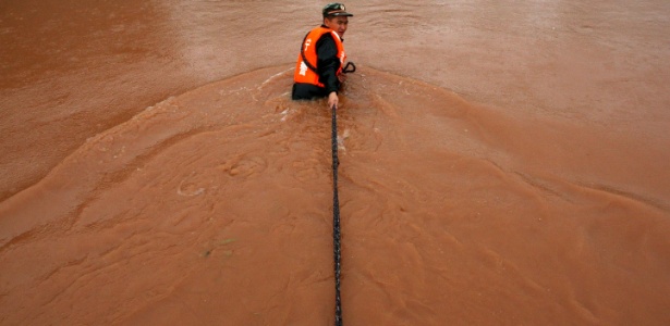 Socorrista puxa canoa em região inundada do sudoeste da China - AFP