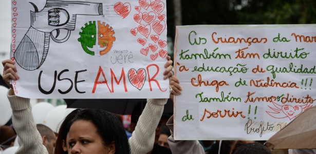 Manifestantes exibem cartazes contra violência, em protesto no Complexo da Maré no último dia 2