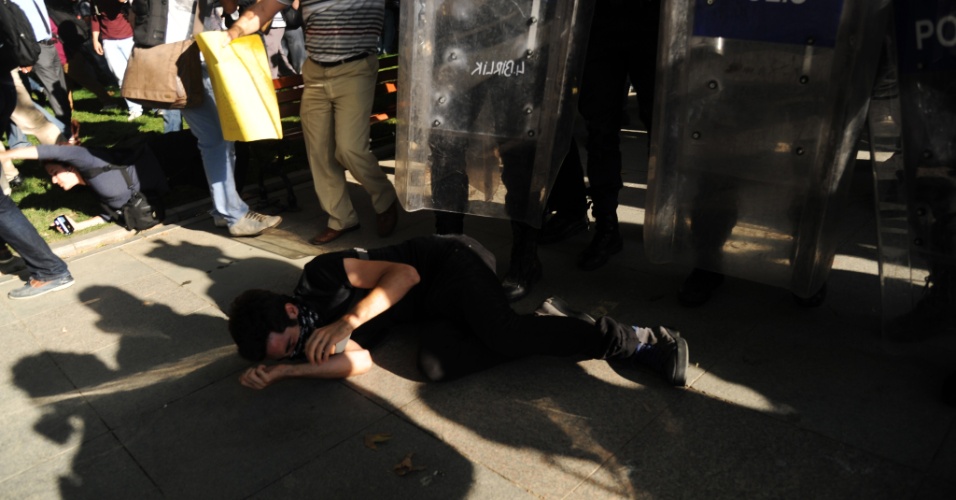 8.jul.2013 - Manifestante fica caído em frente a barreira polícial durante protesto em Istanbul, Turquia. A polícia turca disparou balas de borracha, gás lacrimogêneo e canhões de água para impedir que manifestantes entrassem no parque Gezi, reduto dos protestos contra o governo turco no mês passado