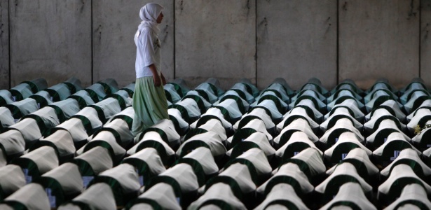 Mulher busca túmulo do pai entre lápides em cerimônia fúnebre em Potocari, perto de Srebrenica